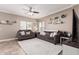 Living room with tiled floors, gray couches, and a ceiling fan at 17774 W Watson Ln, Surprise, AZ 85388