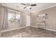 Living room with tiled floors, gray couches, and a ceiling fan at 17774 W Watson Ln, Surprise, AZ 85388