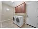 Laundry room with washer, dryer, and upper cabinets at 18007 W Ocotillo Ave, Goodyear, AZ 85338