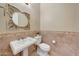 Elegant powder room with pedestal sink and decorative mirror at 18007 W Ocotillo Ave, Goodyear, AZ 85338