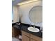 Bathroom with black countertop and round mirror at 1832 N 52Nd St # 205, Phoenix, AZ 85008