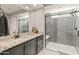 Modern bathroom with granite countertop, dark vanity, and large walk-in shower at 18873 N 262Nd Dr, Buckeye, AZ 85396