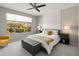 Main bedroom with king-size bed, gray bench, and ceiling fan at 18873 N 262Nd Dr, Buckeye, AZ 85396