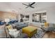 Comfortable living room features gray sofas, yellow ottoman, and large window at 18873 N 262Nd Dr, Buckeye, AZ 85396