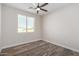 Spacious bedroom featuring wood-look floors and a window with blinds at 23437 E Cactus Forest Rd, Florence, AZ 85132