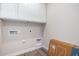 Bright laundry room with white cabinets and tile flooring at 23437 E Cactus Forest Rd, Florence, AZ 85132