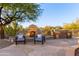 Outdoor kitchen, fireplace, and seating area in a desert landscape at 32032 N 52Nd Way, Cave Creek, AZ 85331