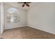 Bedroom with wood-look floors, arched window and ceiling fan at 32032 N 52Nd Way, Cave Creek, AZ 85331