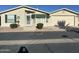 Tan single-story home with attached garage, green awning, and landscaping at 3301 S Goldfield Rd # 4086, Apache Junction, AZ 85119