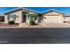 Tan single-story home with a two-car garage and landscaping at 3301 S Goldfield Rd # 4086, Apache Junction, AZ 85119