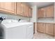 Laundry room with washer, dryer and light wood cabinets at 3301 S Goldfield Rd # 4086, Apache Junction, AZ 85119