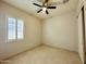 Bright bedroom with tile floors, ceiling fan, and large closet at 3448 E Spring Wheat Ln, Gilbert, AZ 85296