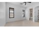 Bright bedroom with a ceiling fan, tile floor, black-trimmed windows, and ensuite bathroom and walk-in closet at 4215 S Willow Springs Trl, Gold Canyon, AZ 85118