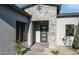 Home entrance with a modern door, stone accents, desert landscaping, and black trim windows at 4215 S Willow Springs Trl, Gold Canyon, AZ 85118