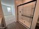 Bathroom with walk-in shower and view into bedroom at 47489 W Kenner Dr, Maricopa, AZ 85139