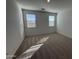 Bright bedroom with carpet flooring and two large windows at 47489 W Kenner Dr, Maricopa, AZ 85139