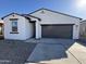 White stucco home with a two-car garage and drought-tolerant landscaping at 47489 W Kenner Dr, Maricopa, AZ 85139