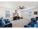 Living room with two sofas, fireplace, and large screen TV at 47558 W Mellen Ln, Maricopa, AZ 85139