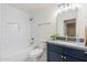 Modern bathroom with navy vanity, white tile, and gold fixtures at 501 W Yukon Dr # 8, Phoenix, AZ 85027