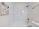 Clean bathroom with white tile, shower, and gold fixtures at 501 W Yukon Dr # 8, Phoenix, AZ 85027