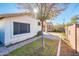 Side yard with paved pathway, grassy areas, and mature trees at 5226 S 15Th St, Phoenix, AZ 85040