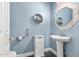 Elegant powder room with pedestal sink and octagonal mirror at 5720 W Robb Ln, Glendale, AZ 85310