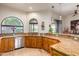 Kitchen with granite counters, wood cabinets, and arched windows at 6168 S Fairway Pl, Gold Canyon, AZ 85118