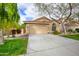 Tan house with tile roof, attached garage, and mature landscaping at 6458 E Raftriver St, Mesa, AZ 85215