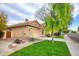 Tan house with tile roof, attached garage, and mature landscaping at 6458 E Raftriver St, Mesa, AZ 85215