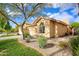 Tan house with tile roof, attached garage, and mature landscaping at 6458 E Raftriver St, Mesa, AZ 85215