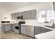 Modern kitchen with gray cabinets, stainless steel appliances, and white countertops at 6458 E Raftriver St, Mesa, AZ 85215