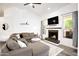 Bright living room featuring a fireplace, large sectional sofa, and hardwood floors at 6458 E Raftriver St, Mesa, AZ 85215