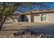 Tan house with teal front door, arched entryway, and gravel landscaping at 6630 E Dreyfus Ave, Scottsdale, AZ 85254