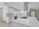 Modern kitchen island with white cabinets and a large quartz countertop at 6630 E Dreyfus Ave, Scottsdale, AZ 85254