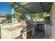 Outdoor kitchen with built-in grill, sink, and covered patio at 6630 E Dreyfus Ave, Scottsdale, AZ 85254