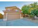 Two story house with a tan exterior and a two car garage at 6811 W Monona Dr, Glendale, AZ 85308