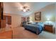 Main bedroom with ceiling fan, large windows, and built-in shelving at 9 N Agua Fria Ln, Casa Grande, AZ 85194