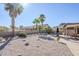 Spacious backyard with gravel, mature plants, and a covered patio with seating at 10255 E Golden Rim Cir, Gold Canyon, AZ 85118