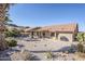 Landscaped backyard with gravel, mature plants, and a covered patio area at 10255 E Golden Rim Cir, Gold Canyon, AZ 85118