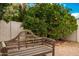 Relaxing backyard with wooden bench near a lush orange tree at 10428 E Hercules Dr, Sun Lakes, AZ 85248