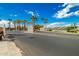 Gated community entrance with palm trees and a lake view at 10428 E Hercules Dr, Sun Lakes, AZ 85248