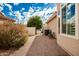 Landscaped side yard with gravel, bench, and gated access at 10428 E Hercules Dr, Sun Lakes, AZ 85248