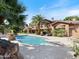 A backyard pool is surrounded by desert landscaping and a covered patio at 11571 E Cochise Dr, Scottsdale, AZ 85259