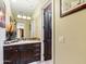 Bathroom featuring dark wood cabinetry, marble countertops, and a large mirror at 11571 E Cochise Dr, Scottsdale, AZ 85259