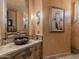 Elegant bathroom with a custom sink, decorative mirror, and unique wall texture at 11571 E Cochise Dr, Scottsdale, AZ 85259