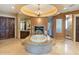 An opulent bathroom offers a jetted tub with stone surround and large mirrors at 11571 E Cochise Dr, Scottsdale, AZ 85259
