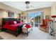 Elegant bedroom featuring a tufted black headboard and red bedding, with a patio view at 11571 E Cochise Dr, Scottsdale, AZ 85259