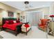 Elegant bedroom featuring a tufted black headboard and red bedding, complemented by ornate furniture and a ceiling fan at 11571 E Cochise Dr, Scottsdale, AZ 85259