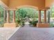 Beautiful courtyard featuring a fountain and a manicured garden, framed by arched columns and a brick pathway at 11571 E Cochise Dr, Scottsdale, AZ 85259