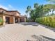 Spacious driveway with brick pavers, leading to a multi-car garage and lush landscaping at 11571 E Cochise Dr, Scottsdale, AZ 85259